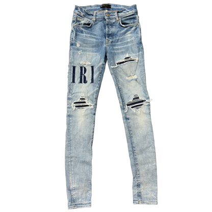Amiri Distressed Repaired Denim Jeans with Logo